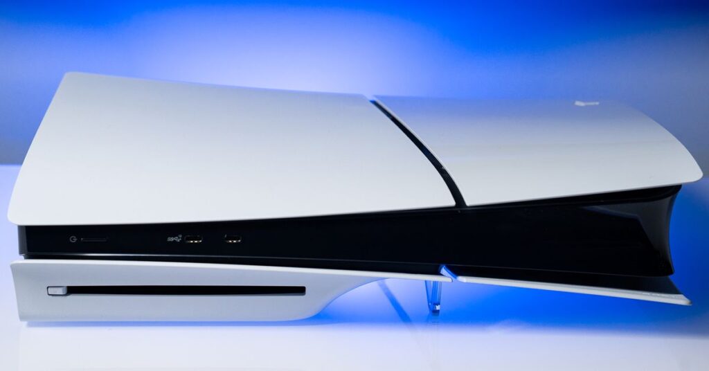 The PlayStation 5 slim sitting on a white surface with a blue backlight.
